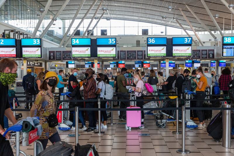 Passengers queue at check-in desks at Cape Town International Airport, South Africa. Bloomberg
