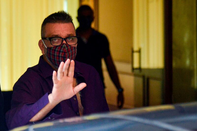 Bollywood actor Sanjay Dutt waves as he returns home after being discharged from a hospital in Mumbai on August 10, 2020.  / AFP / Sujit JAISWAL
