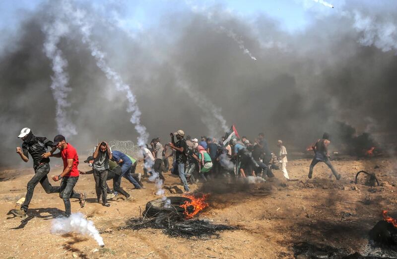 epa06795745 Palestinian protesters run for cover from Israeli tear-gas during clashes after Friday protests near the border east Gaza City, 08 June 2018 (issued 09 June 2018). Reports state that a twelve year old boy and other three Palestinians were killed and more than 600 protesters were wounded during the clashes near the border eastern Gaza Strip. Protesters plan to call for the right of Palestinian refugees across the Middle East to return to homes they fled in the war surrounding the 1948 creation of Israel.  EPA/MOHAMMED SABER