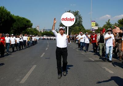 Kemal Kilicdaroglu, with a sign reading 'justice' in Turkish, pictured in July 2017 walking in Istanbul on the final stage of his 25-day march against the detention of  party colleague Enis Berberoglu. Reuters