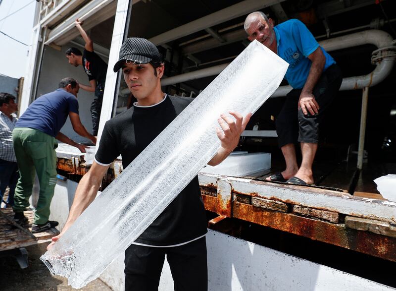 An Iraqi man buys ice blocks at a factory in Sadr City, east of the capital Baghdad, amid power outages and soaring temperatures.