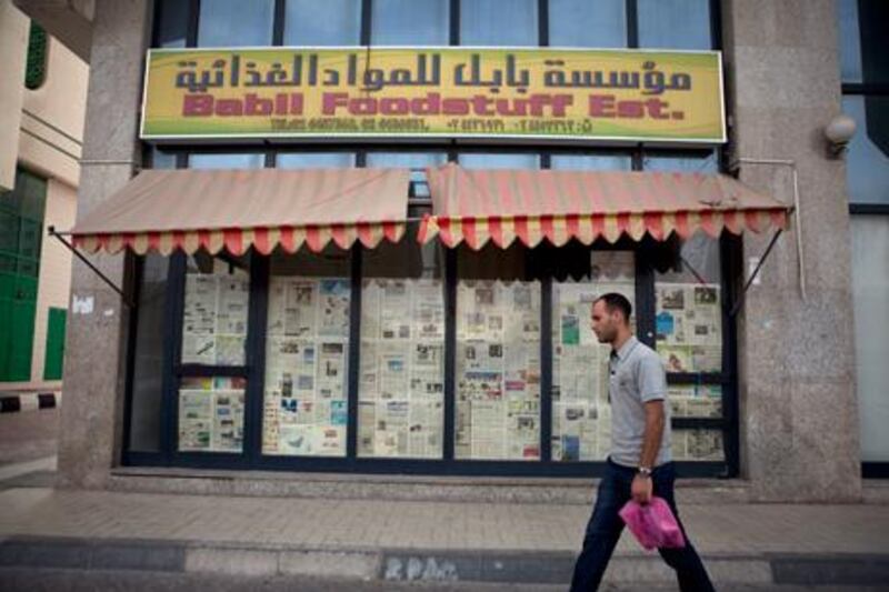 A man walks by the Babil Foodstuff Est., a recently closed convenience store in the city block between Airport and Muroor, and Delma and Mohamed Bin Khalifa streets in Abu Dhabi.  Silvia Razgova/The National