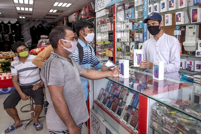 Abu Dhabi, United Arab Emirates, April 23, 2020.  Customers at a mobile phone shop at the Mussafah 32 area during the Coronavirus pandemic.
Victor Besa / The National
Section:  NA
For: stock images and standalone