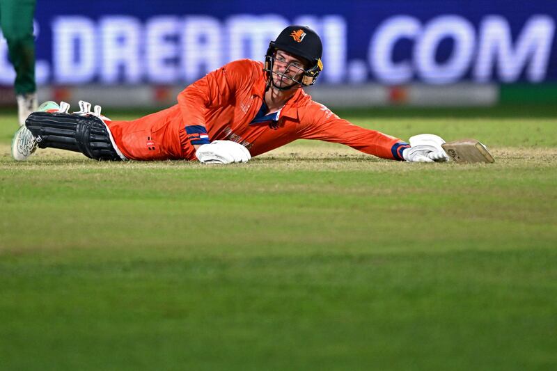 Netherlands' captain Scott Edwards dives to make his ground. AFP