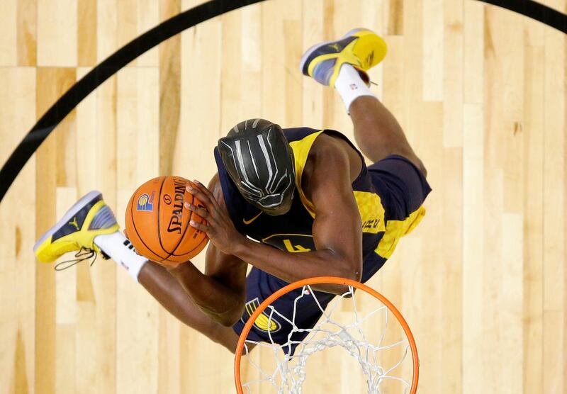 Indiana Pacers' Victor Oladipo dunks while wearing a mask from the movie "Black Panther" during the NBA basketball All-Star weekend slam dunk contest in Los Angeles. Bob Donnan / via AP