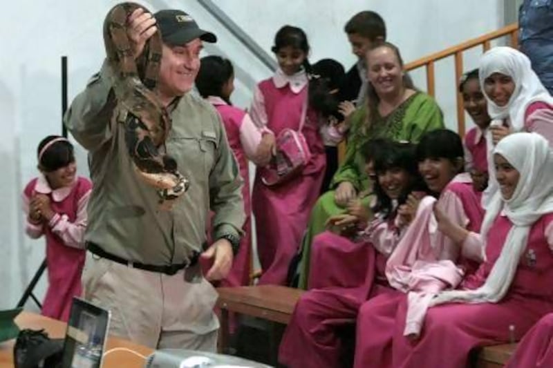 Dr Brady Barr displays a boa constrictor to children at Al Ain Zoo.