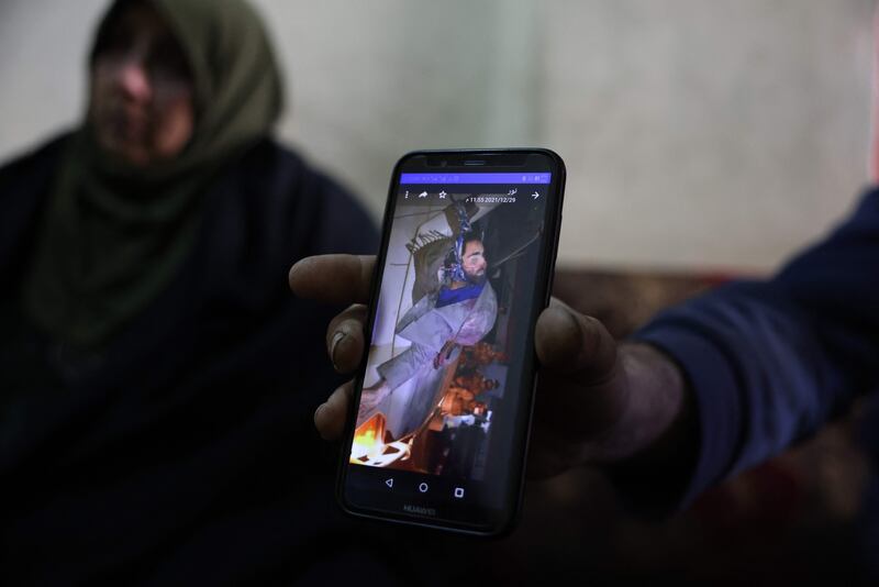Ghufran, the mother of Zakaria Al Adl, a member of ISIS killed in Iraq, talks as one of her sons shows a photo of his brother during an interview in her house.