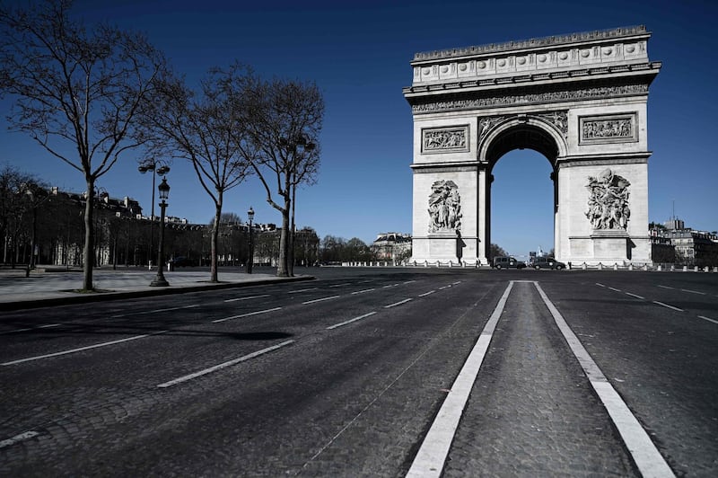 An empty street leading to the Arc de Triomphe in Paris.  AFP