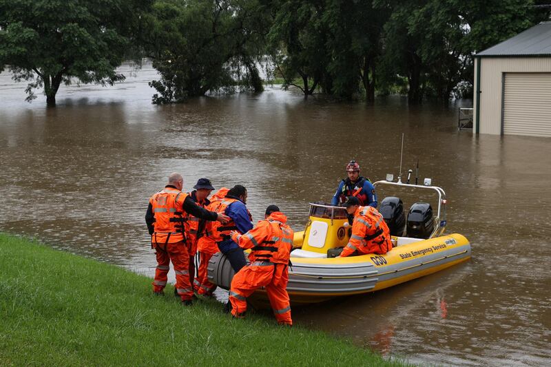 State Emergency Service personnel load a dentist onto a boat to transport him from the suburb of Windsor to North Richmond across floodwaters, so he can attend to patients unreachable by car, as the state of New South Wales experiences widespread flooding and severe weather, in Sydney. Reuters