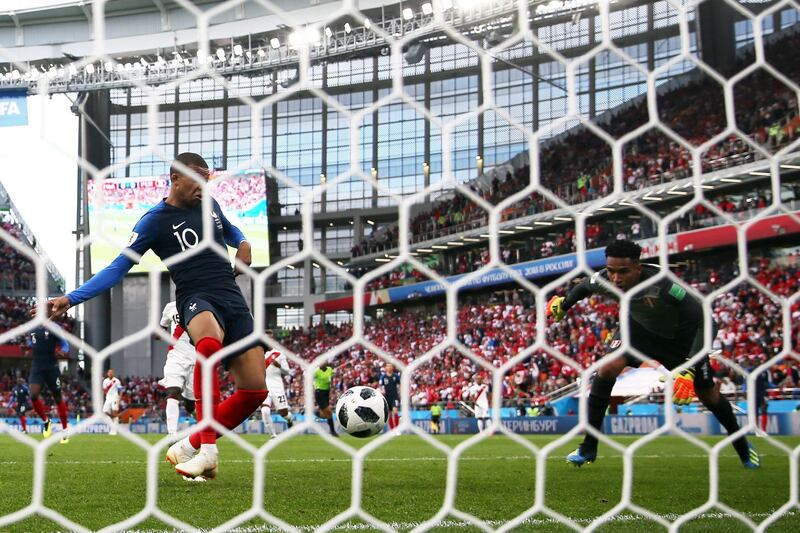 Kylian Mbappe of France scores his team's first goal past Pedro Gallese of Peru. Catherine Ivill / Getty Images