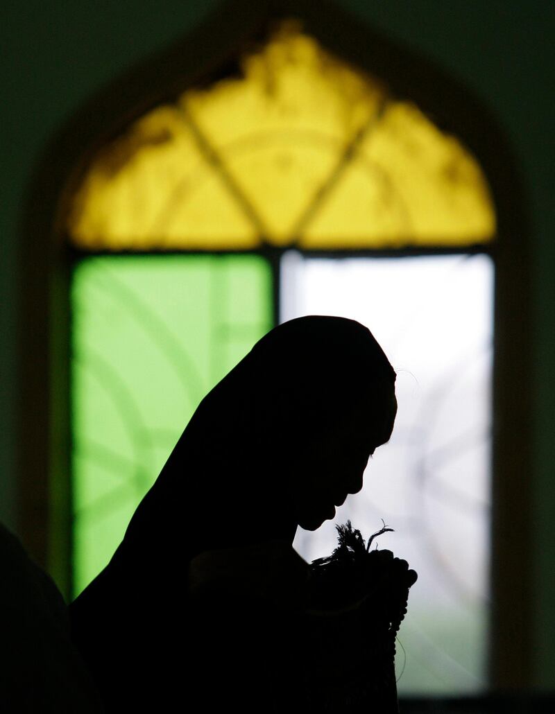 A Filipino Muslim woman enters a mosque to pray during the first day of the holy fasting month of Ramadan in suburban Paranaque, south of Manila, Philippines on Monday, Aug. 1, 2011. During Ramadan, the holiest month in Islamic calendar, Muslims refrain from eating, drinking, smoking and sex from dawn to dusk. (AP Photo/Aaron Favila) *** Local Caption ***  Philippines Ramadan.JPEG-04e33.jpg