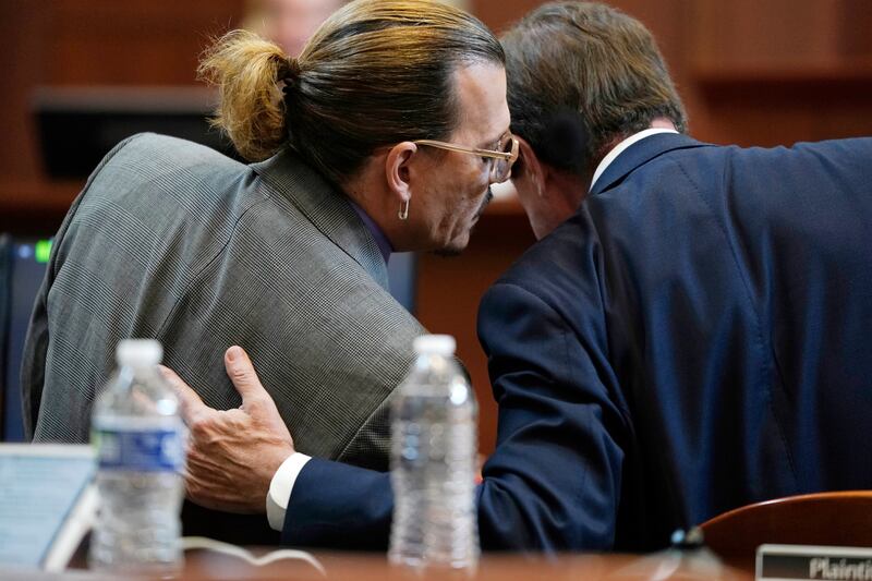 Depp talks to his lawyer in the courtroom. Pool Photo via AP