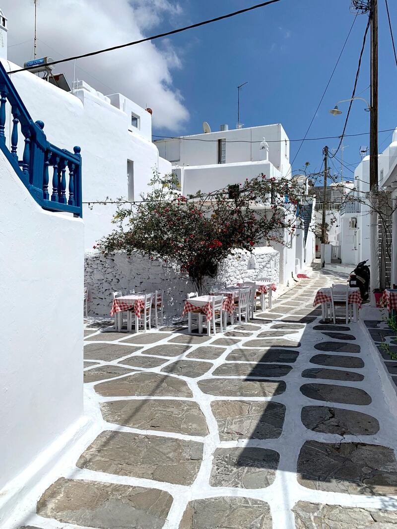 Restaurant tables are set on the Greek island of Mykonos.