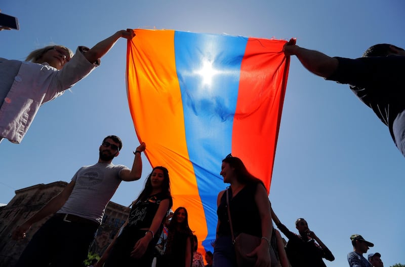 Supporters of opposition lawmaker Nikol Pashinian carry a large Armenian flag as they protest in Republic Square in Yerevan. Sergei Grits / AP Photo