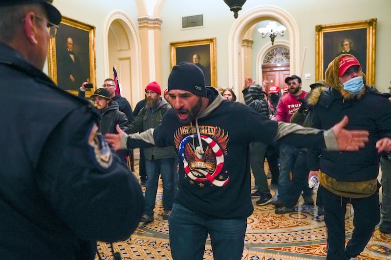 Trump supporters, including Doug Jensen, centre, confront US Capitol Police in the hallway outside the Senate chamber at the Capitol. AP