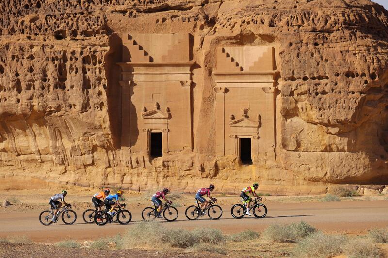 The pack rides past ancient Nabataean carved tombs 