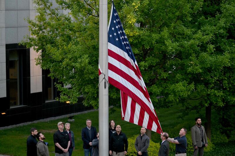 Employees raise the flag outside the US embassy in Kyiv on May 18.  AFP