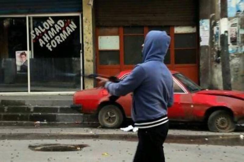 A Lebanese Sunni gunman fires his weapon in Tripoli in northern Lebanon Saturday. One person was killed and several soldiers wounded in street battles in Tripoli in a second day of violence between Sunni supporters of the anti-Syrian opposition and Alawites loyal to Syria regime.