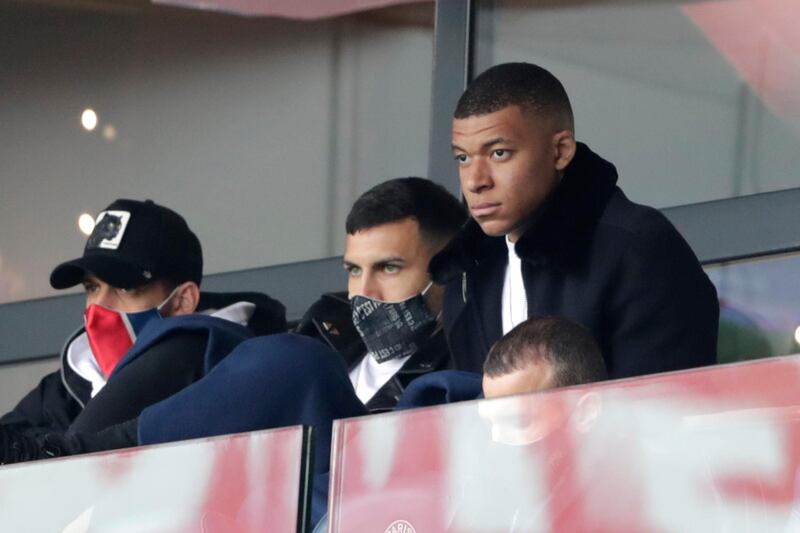 PSG striker Kylian Mbappe, right, watches from the stands. AP