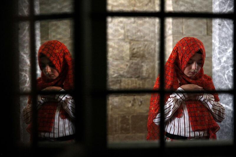 A Muslim girl prays inside Hala Sultan Tekke mosque in the coastal city of Larnaca in Cyprus on July 28, 2014. Yiannis Kourtoglou/AFP Photo