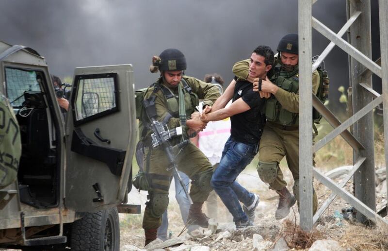 Israeli soldiers detain a protester during a demonstration by Palestinians protesting against the Israeli-built West Bank separation barrier and calling for the right of return for Palestinian refugees, in the northern West Bank city of Tulkarem. Nasser Ishtayeh / AP 