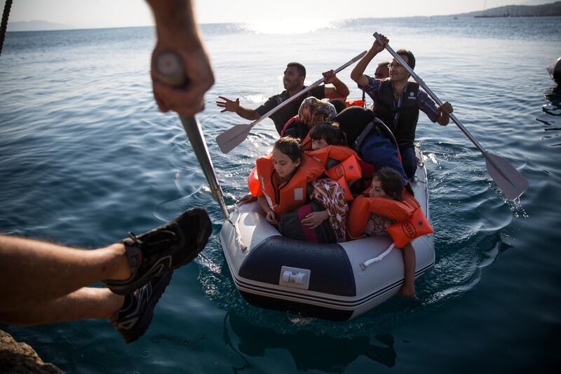 KOS, GREECE - AUGUST 30:  A Syrian family arrive in an inflatable dinghy at Kos ferry port after the crossing from Turkey on August 30, 2015 in Kos, Greece. Migrants from many parts of the Middle East and African nations continue to flood into Europe before heading from Athens, north to the Macedonian border. Since the beginning of 2015 the number of migrants using the so-called 'Balkans route' has exploded with migrants arriving in Greece from Turkey and then travelling on through Macedonia and Serbia before entering the EU via Hungary. The number of people leaving their homes in war torn countries such as Syria, marks the largest migration of people since World War II.  (Photo by Dan Kitwood/Getty Images)