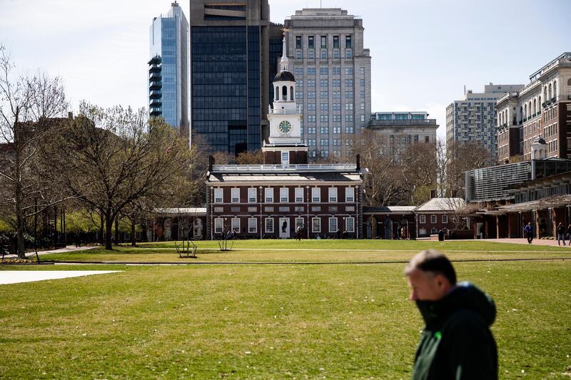 A pedestrian walks past the sparsely populated Independence Mall in Philadelphia, Monday, March 16, 2020.  In a new front to slow the spread of the new coronavirus in Pennsylvania, Gov. Tom Wolf ordered all restaurants and bars to close their dine-in facilities in five heavily populated counties starting Monday. According to the World  Health Organization, most people recover in about two to six weeks, depending on the severity of the illness.  (AP Photo/Matt Rourke)