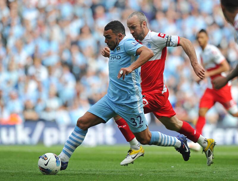Manchester City's Argentinian striker Carlos Tevez battles for the ball with Queens Park Rangers' midfielder Shaun Derry. AFP