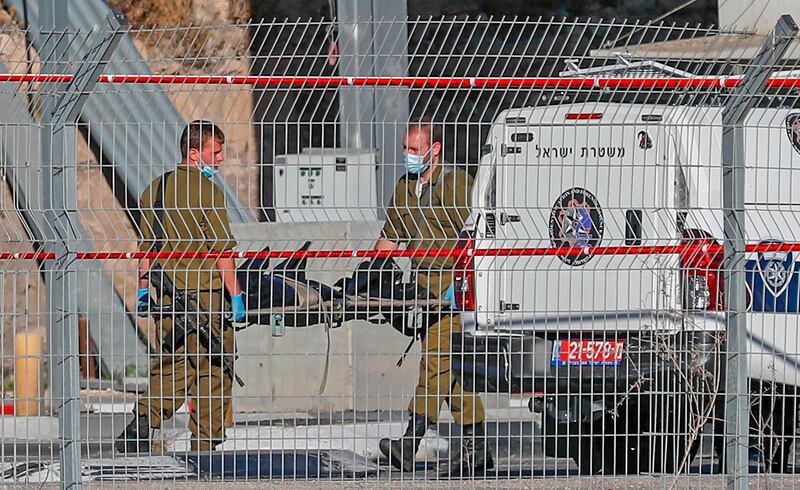 Israeli soldiers remove the body of a Palestinian Ahmad Erakat, who was shot dead at the site of a reported ramming attack, at a checkpoint in the occupied West Bank near the village of Abu Dis on June 23, 2020. A Palestinian man was shot dead at a checkpoint in the occupied West Bank after driving his car "quickly" towards a border officer, Israeli police said. / AFP / AHMAD GHARABLI
