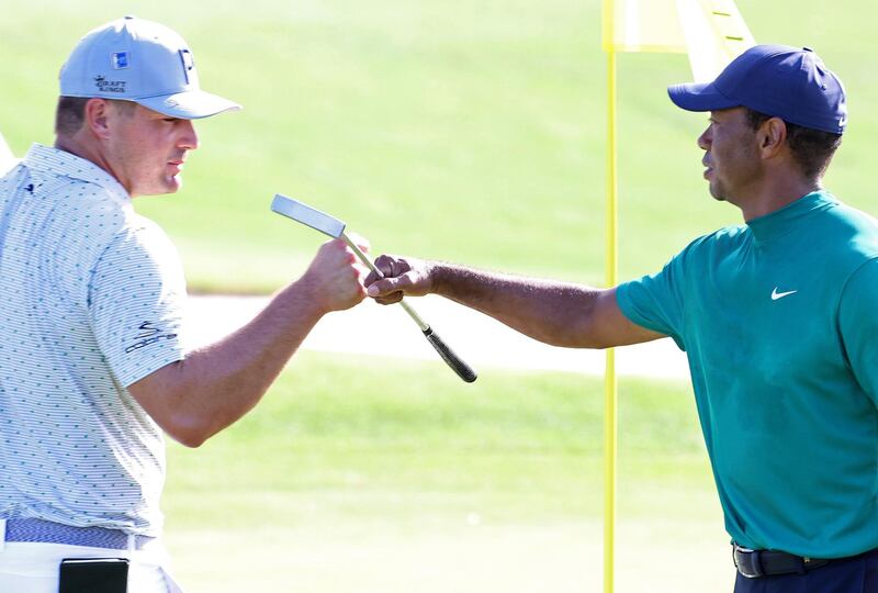 Bryson DeChambeau and Tiger Woods bump fists on the 18th green during a practice round prior to the Masters at Augusta National Golf Club. AFP