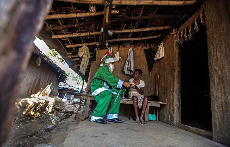 A man dressed as Santa Claus distributes solar lamps to the tribal families, inside Sanjay Gandhi National Park, in Mumbai, India. The families do not have electricity as the village is not connected to an electric grid. As part of a project, around 20 homes will be given solar lanterns.  Divyakant Solankant / EPA