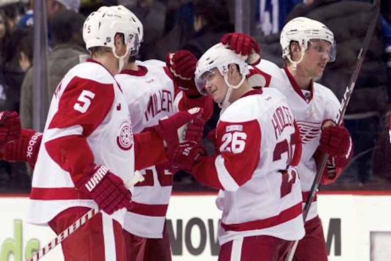 VANCOUVER, CANADA - FEBRUARY 2: Jiri Hudler #26 of the Detroit Red Wings is congratulated by Nicklas Lidstrom #5 and Justin Abdelkader #8 after scoring the game winning goal in the shootout to defeat the Vancouver Canucks 3-2 in NHL action on February 02, 2012 at Rogers Arena in Vancouver, British Columbia, Canada.   Rich Lam/Getty Images/AFP== FOR NEWSPAPERS, INTERNET, TELCOS & TELEVISION USE ONLY ==
 *** Local Caption ***  787575-01-09.jpg