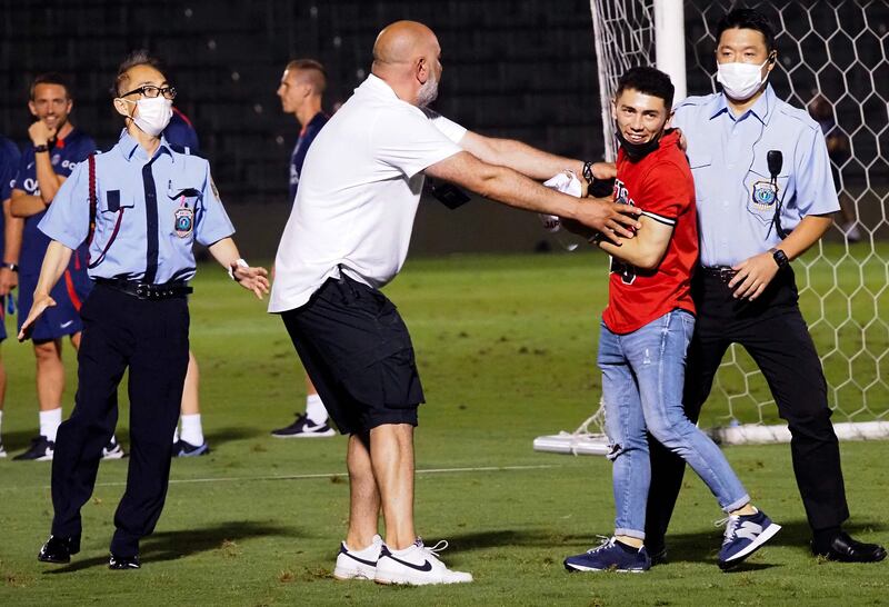 Another pitch invader is removed from PSG's training session. AFP