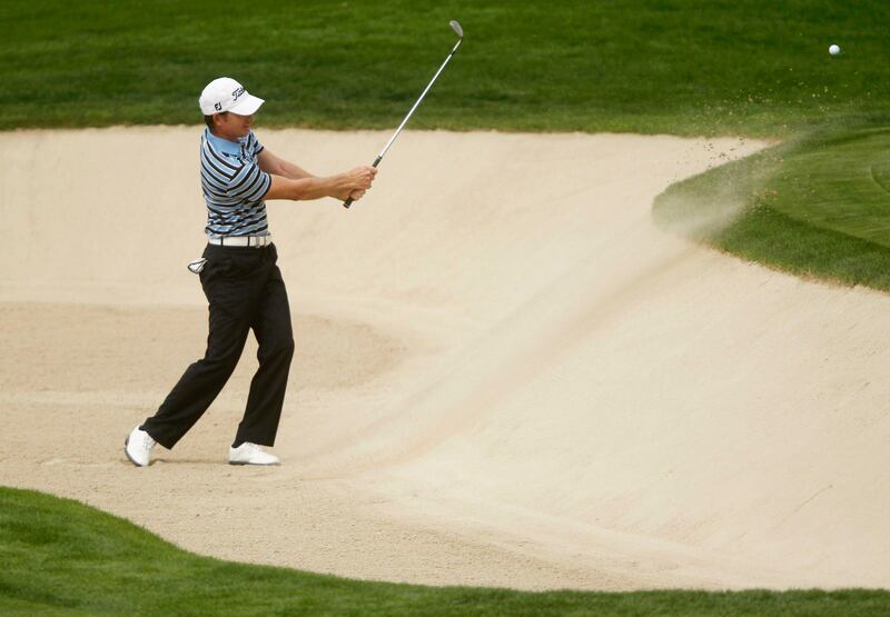 Brett Rumford of Australia hits out of a bunker at the 13th green during the second round of the Dubai Desert Classic at the Emirates Golf Club February 1, 2013. REUTERS/Jumana El Heloueh (UNITED ARAB EMIRATES - Tags: SPORT GOLF) *** Local Caption ***  DUB23_GOLF-EUROPEAN_0201_11.JPG