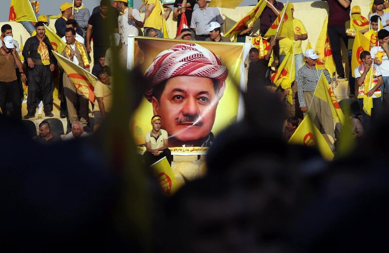 Iraqi Kurds wave flags and a poster of Massud Barzani, leader of the Kurdistan Democratic Party, during a rally at the Franco Hariri Stadium, in Arbil. Safin Hamed/AFP