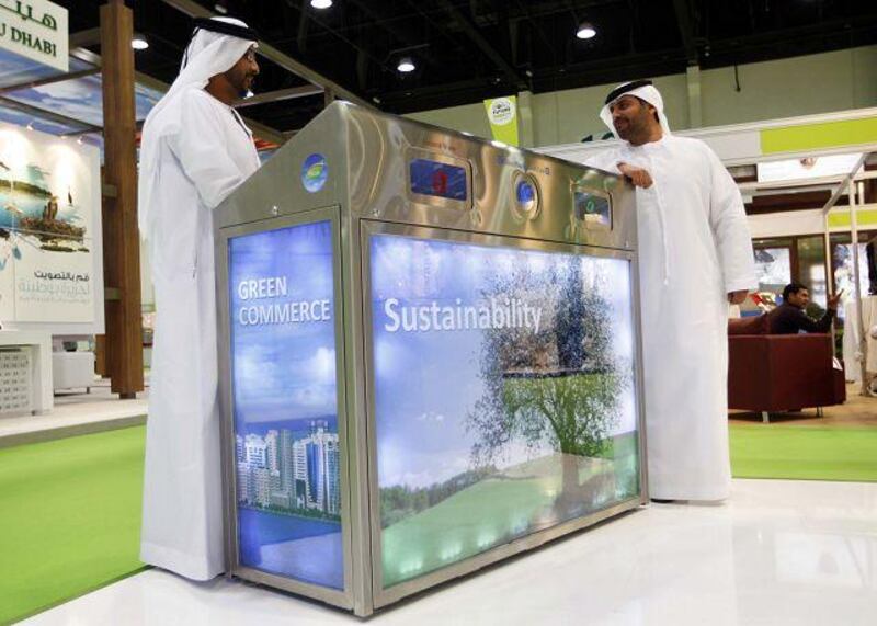 Abboud al Braiki, left, and Zeyad al Khaja display their recycling bin at the World Future Energy Summit in Abu Dhabi.