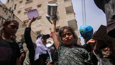 Displaced Palestinians carry empty pots and pans as they call for more aid during a demonstration in Deir Al Balah, central Gaza, on April 25. Bloomberg