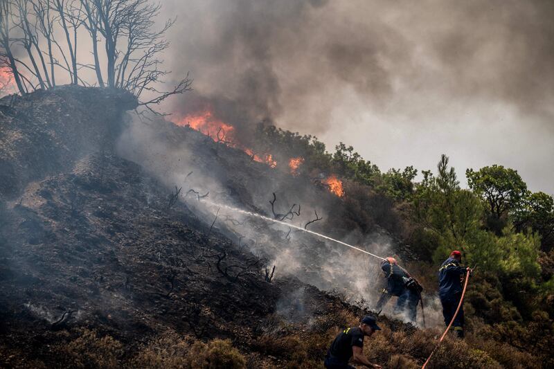 Firefighters try to contain a fire near Vati, on the Greek Aegean island of Rhodes on Wednesday. Thousands were evacuated in both Rhodes and Corfu. AFP