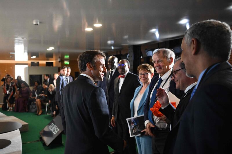 French President Emmanuel Macron greets those attending the Summit for a New Global Financial Pact in Paris. AFP