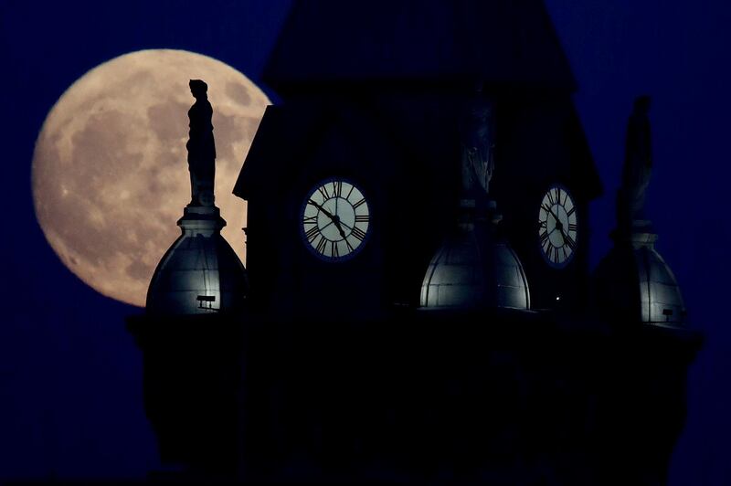 The moon rises in its waxing gibbous stage behind a statue atop the Erie County Court Building in Buffalo, New York. Julio Cortez / AP Photo