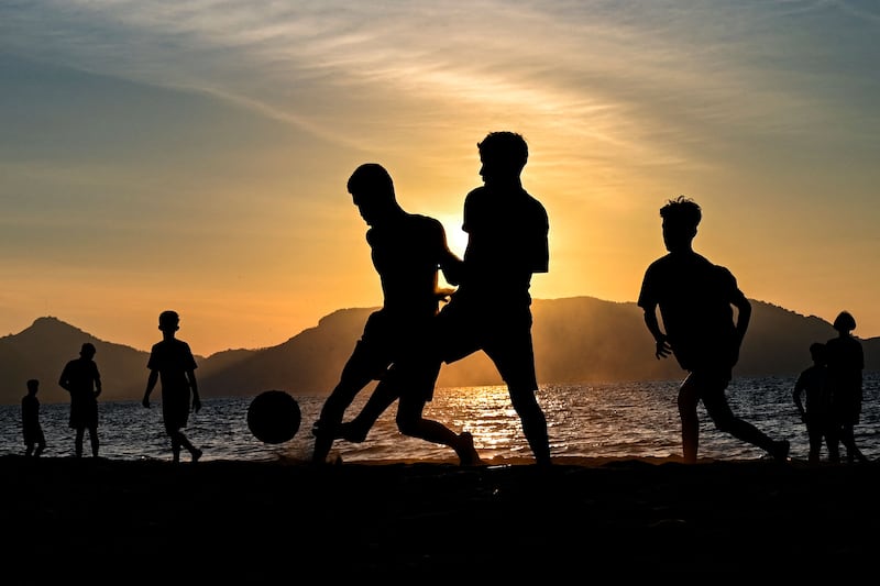 Young people play football on a beach as the sun sets in Banda Aceh, Indonesia. AFP