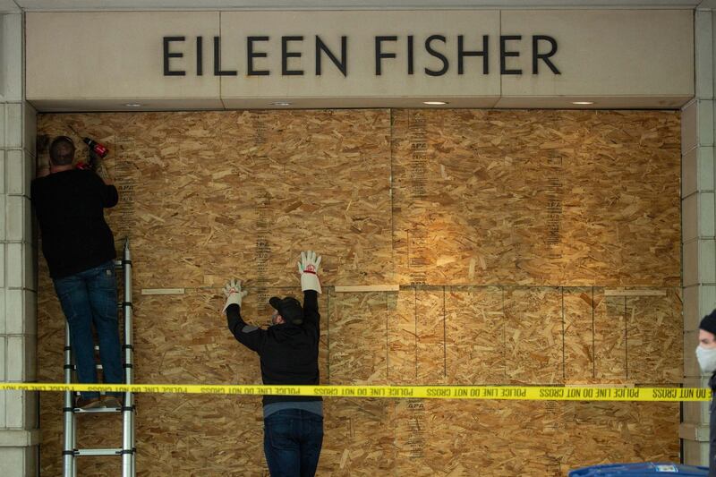 SEATTLE, WA - MAY 31: Workers board up an Eileen Fisher retail location on the day after violent protests due to the recent death of George Floyd on May 31, 2020 in Seattle, Washington. Protests began again peacefully Sunday after days of violent scenes in the city. (Photo by David Ryder/Getty Images)