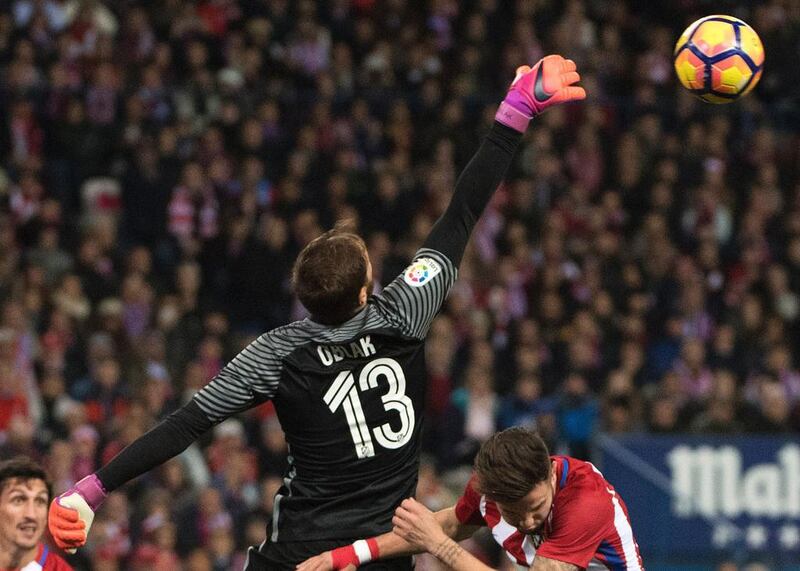 Atletico Madrid’s Slovenian goalkeeper Jan Oblak, left, clears the ball. Curto de la Torre / AFP