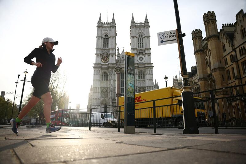 A woman jogs near a polling station sign in Westminster, London. Reuters