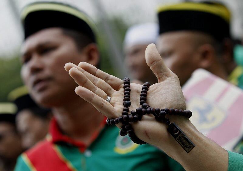 A Muslim man holds a prayer beads while recites a prayer during a protest against the use of the word 'Allah' by Christians, in front of the Court of Appeal in Putrajaya, outside Kuala Lumpur, Malaysia.  EPA/Shamshahrin Shamsudin 