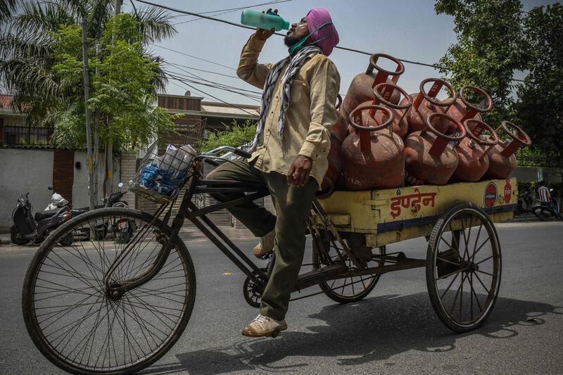 A gas cylinder delivery man quenches his thirst during his shift on a hot summer afternoon in Amritsar, India.