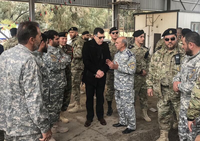The head of Libya's UN-backed unity government, Fayez al-Sarraj (C), visits military and security commanders of the government forces who supervised recapture of the checkpoint 27 in Janzour, between Tripoli and the coastal town of Zawiya on April 5, 2019, hours after Haftar's froces were pushed back from the key spot, less than 30 kilometres (18 miles) from the capital. Forces loyal to Libyan strongman Khalifa Haftar were pushed back on April 5 from the key checkpoint by pro-government forces. The Tripoli Protection Force, an alliance of pro-government militias in the capital, said its fighters had taken part in the recapture of the checkpoint 27 kilometres (17 miles) to its south.
 / AFP / Mahmud TURKIA
