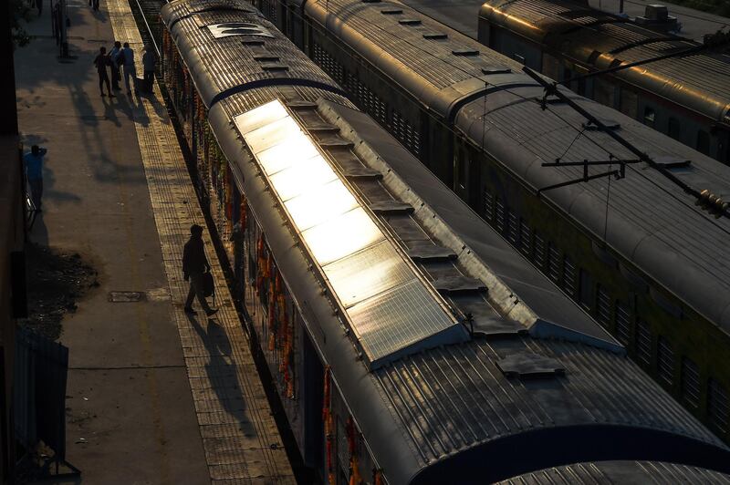 In this photograph taken on July 18, 2017 Indian commuters board the 1600 HP solar-powered DEMU (diesel electrical multiple unit) train is seen parked at Sarai Rohilla railway station in New Delhi. - India has added solar panels to the roof of a train in a national first as it tries to reduce its massive carbon footprint and modernise its vast colonial-era rail network. The lighting, fans and information displays inside the train -- once powered by diesel -- will run off the sun's energy after the panels were fitted to the carriage. (Photo by CHANDAN KHANNA / AFP) / TO GO WITH 'INDIA-TRANSPORT-RAIL-CLIMATE-WARMING' BY ABHAYA.