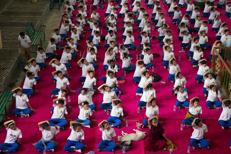 A dog sleeps in the midst of exile Tibetan school children who participate in a joint yoga session at the Tsuglakhang temple to mark the International Yoga Day in Dharmsala, India. Ashwini Bhatia / AP Photo