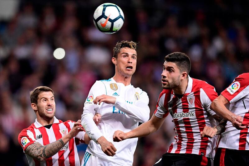 TOPSHOT - Athletic Bilbao's Spanish defender Inigo Martinez (L) and Athletic Bilbao's Spanish defender Unai Nunez (R) vie with Real Madrid's Portuguese forward Cristiano Ronaldo (C) during the Spanish league football match Real Madrid CF against Athletic Club Bilbao at the Santiago Bernabeu stadium in Madrid on April 18, 2018. / AFP PHOTO / JAVIER SORIANO